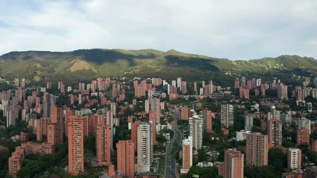 Cinematic Drone Aerial Tilt Up Shot of Modern Residental Area Of Medellin City El Poblado Colombia With Buildings and Street Traffic 4k