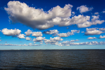 Naklejka na ściany i meble blue sky and white clouds over the river