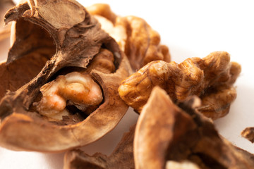 Peeled walnuts with broken shell isolated on white background. Macro. Walnuts close-up.