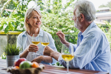 Senior couple enjoy drinking and clinking glass of wine to relax at home, senior retirement concept