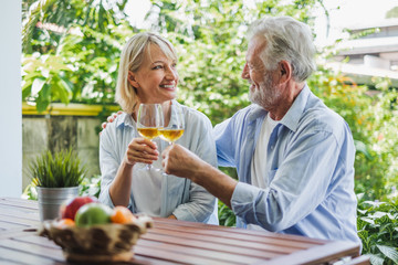 Senior couple enjoy drinking and clinking glass of wine to relax at home, senior retirement concept - Powered by Adobe