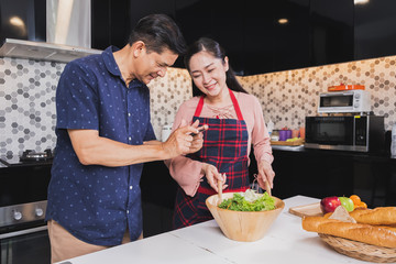 Asian senior couple enjoy cooking in kitchen at home