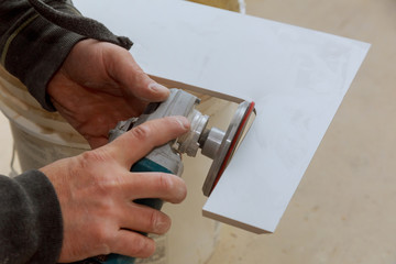 Worker cutting flooring tile with an diamond electric saw blade a construction site
