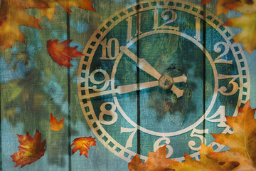 Fototapeta na wymiar Clock and autumn leaves background - daylight saving time concept