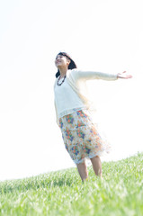 草原で深呼吸をする女性