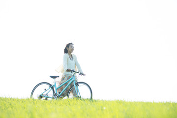 草原で自転車を押す女性