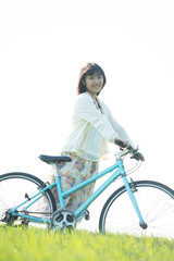 Obraz premium 草原で自転車を押す女性