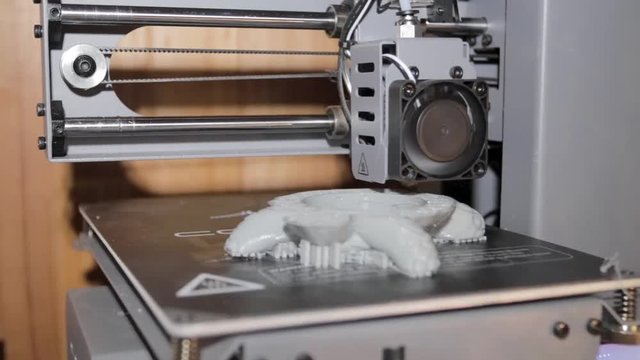 Level shot of an FDM 3D printer creating an object with hot plastic.
