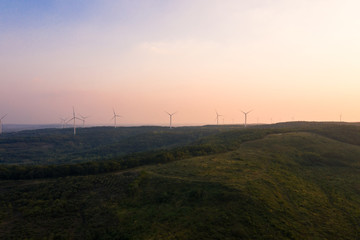 The windmills on the top of a mountain. They generate green energy from the nature.
