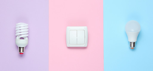 Economy light bulbs, the switch on the pastel background. Top view. Minimalism electro consumer concept