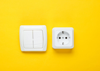 Electro socket, switch on a yellow wall background, minimalism