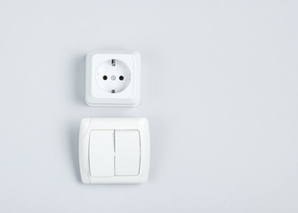 Electro socket, switch on gray wall background, minimalism