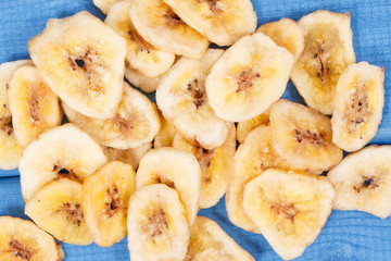 Dried banana chips for snack or dessert on blue boards
