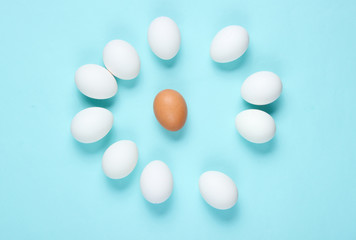 Bullying concept with eggs on a blue background. Top view, minimalism