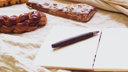 Breads and toast for breakfast and note book on white bed sheet background, Healthy breakfast. Morning health lifestyle concept idea background