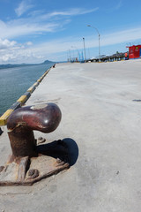 Rusty mooring bollard with ship ropes