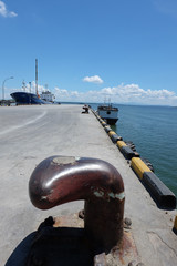 Rusty mooring bollard with ship ropes
