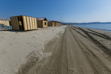 Fototapeta na wymiar Construction of houses for the recreation center on the sandy sea beach. Construction of a resort area on the sea.