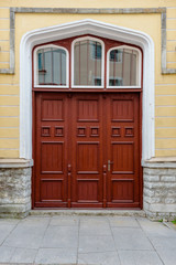 Facade of old gray brick house with wooden door