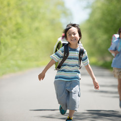 一本道を走る小学生