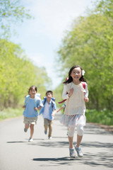 Fototapeta premium 一本道を走る小学生