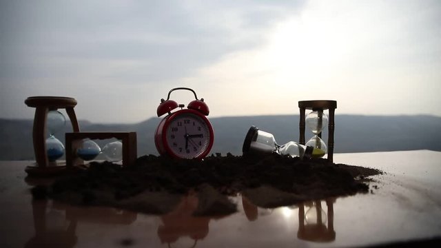 Time concept. Silhouette of Hourglass clock and smoke on blurred nature background at sunset time, or symbols of time under smoke, time ends or love ends. Optimistic or pessimistic ideas. 