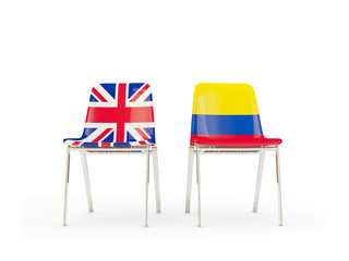 Two chairs with flags of United Kingdom and colombia isolated on white