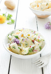 frischer selbstgemachter Kartoffelsalat Schale Tisch essbare Blüten frische Kräuter