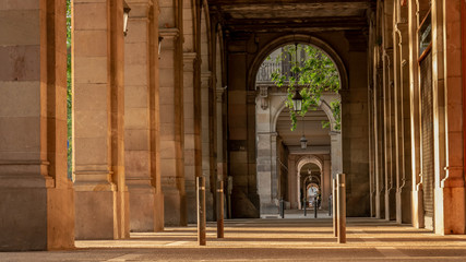 Street with pillars in Barcelona, Spain. Tunnel view.