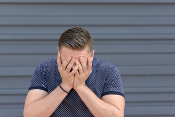 Depressed young man with his head in his hands