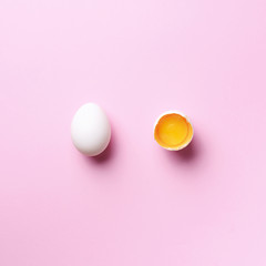 Food concept with broken egg and whole one on pink background. Top view. Creative pattern in minimal style. Flat lay. Square crop