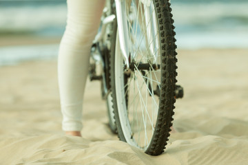 Naklejka premium Unrecognizable woman bike cycling on sand
