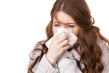 Sick freezing woman sneezing in tissue