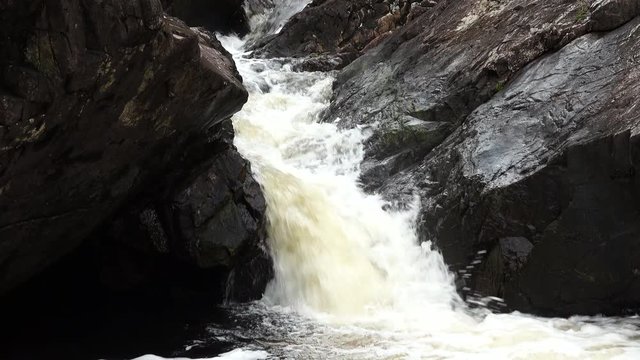 footage of a secret waterfall near the village of kinlochleven in the highland argyll region of scotland on the west highland way near fort william on a spring day showing water flowing downstream