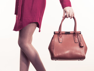 Female holding brown leather bag