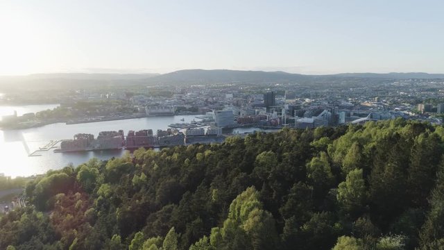 4K aerial of the Oslo city line with backdrop of Oslo and the construction of Bjoervika, a popular tourist attraction with the Munch museum, Barcode, Opera and Soerenga, in sunset with pan motion.