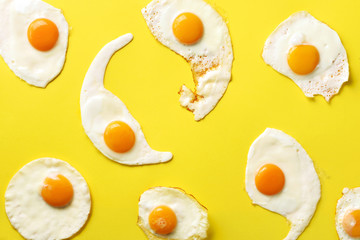 Fried eggs or scrambled eggs pattern on yellow background. Creative food concept. Top view. Minimalistic style