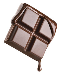 Melted chocolate pours into a piece of chocolate bar isolated on white background.