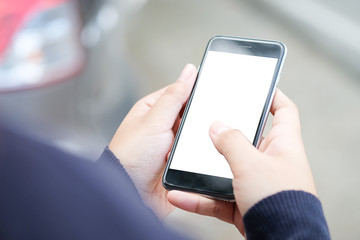 Cropped shot view of man hands holding smart phone with blank copy space screen for your text message or information content, female reading text message on cell telephone during in urban setting.