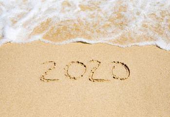 New Year 2020 written on the beach sand