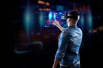 Portrait of a man with glasses of virtual reality, vr, interacts with a virtual screen. The concept of the future is here, applications complement reality, the interface of virtual reality