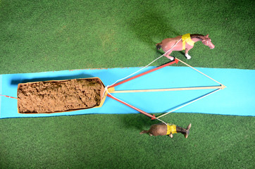 Model arrangement with two animals lowing a boat on a channel, and colored arrows that illustrate how the paralellogram of forces works.