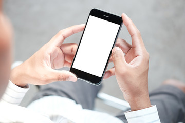 Cropped shot view of man hands holding smart phone with blank copy space screen for your text message or information content, female reading text message on cell telephone during in urban setting.