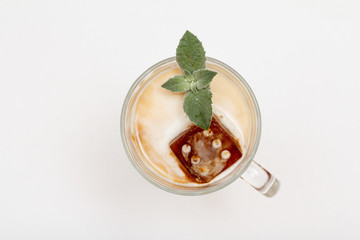 Glass of delicious milkshake or smoothie with chocolate ice and leaves of mint.