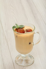 Glass of delicious milkshake or smoothie with chocolate ice and leaves of mint.