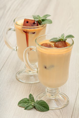 Two glasses of delicious milkshake with chocolate ice and leaves of mint.
