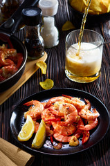seafood at the bar, composition of black plate with shrimp lemon beer chips