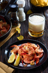 seafood at the bar, composition of black plate with shrimp lemon beer chips
