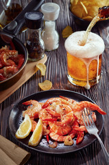 seafood at the bar, composition of black plate with shrimp lemon beer chips