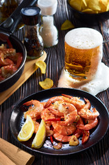 seafood at the bar, composition of black plate with shrimp lemon beer chips